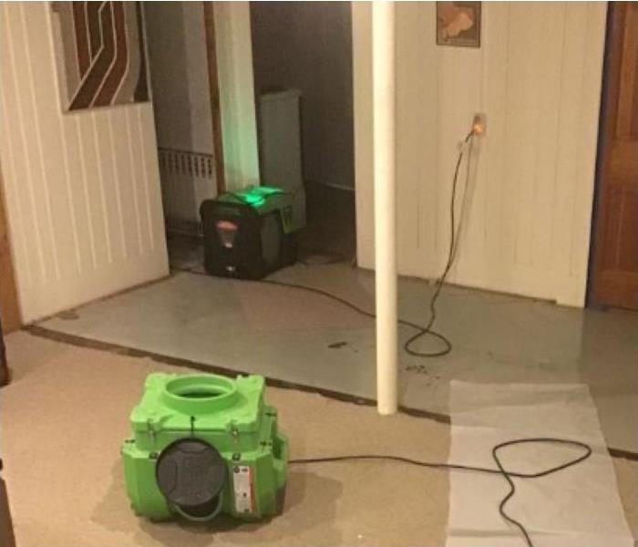 equipment in main room drying floor with half carpet removed