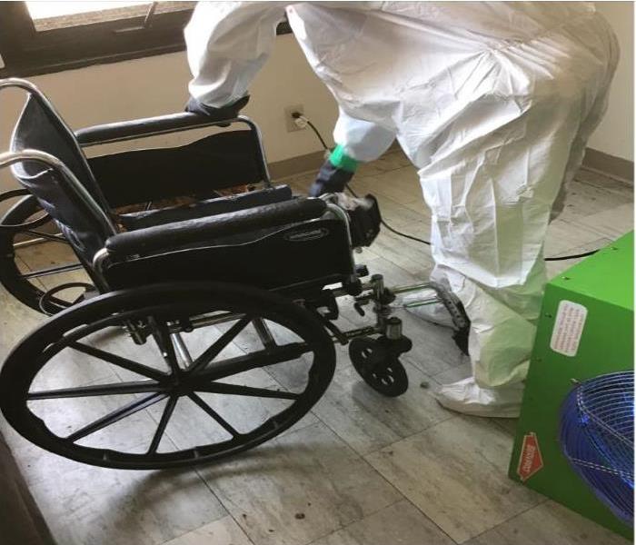 technician cleaning wheelchair after smoke damage